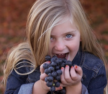 Juliana Layla eating a grape cluster